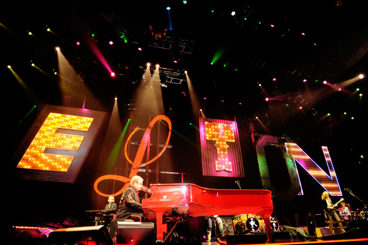 Elton John – Elton und sein rotes Piano begeistern 8000 Zuschauer in Düsseldorf. – Um dann direkt im Neonlicht seines Namens loszulegen.