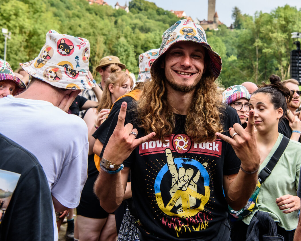 Im idyllischen 'Zaubertal' feiern Tausende Fans mit Peter Fox, Marteria, Bilderbuch, Broilers, Donots, Provinz u.v.a. – Kopfbedeckung schützt vor Regen.